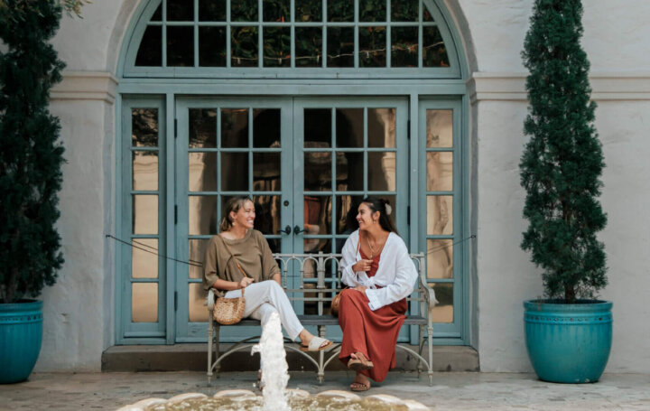 2 people sitting on a bench at Honolulu Museum of Art courtyard